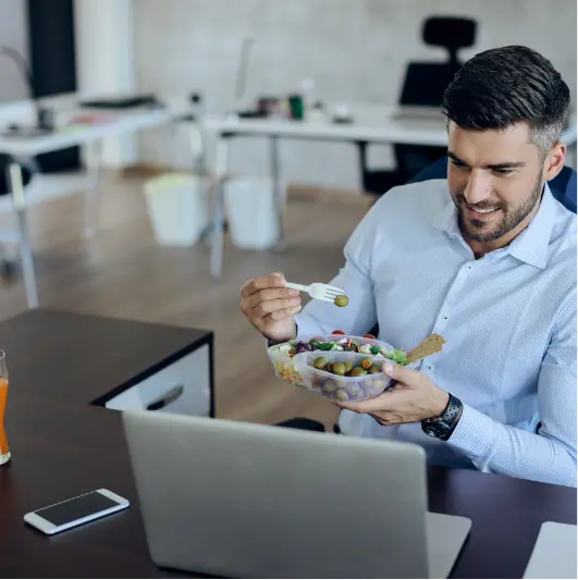 happy-entrepreneur-eating-healthy-food-while-using-2024-12-13-18-37-05-utc